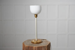 Swedish modern table light from the 1930s to 1940s. The light is likely by Böhlmarks SE. It has a foot in brass with a white stem.