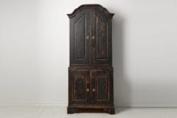 Tall Swedish rococo cabinet made by hand in northern Sweden. The cabinet is a genuine country house furniture from the late 18th century. The cabinet is made from solid pine into two parts.
