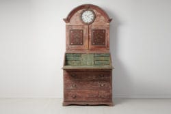 Discover a Swedish antique remarkable clock cabinet with a writing desk. Adorned with historical paintings and original clock mechanism