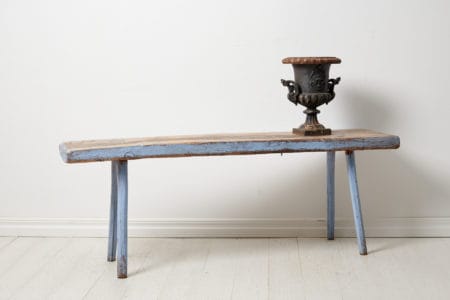 Discover a Swedish antique country bench—handmade in pine, adorned with aged paint and historic graffiti. Embrace unique charm and character.