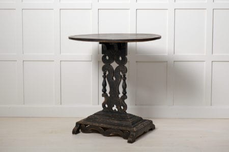 Swedish antique ornate table with an oval table top from northern Sweden made around 1880. The frame is made in solid pine and painted black