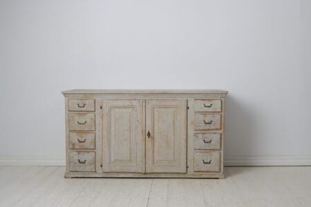 Early low and wide sideboard from 19th century Sweden. This genuine country house furniture was made around 1820 to 1830 in northern Sweden,