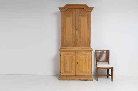 Country house cabinet in baroque style from the late 1700s. The cabinet is in two parts and hand-made in Sweden. On the outside the aged wood is visible with the grain