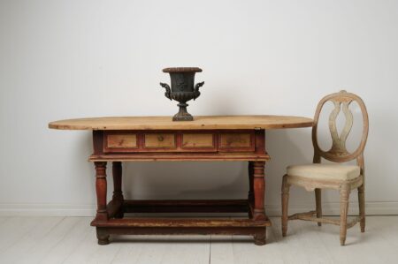 Unusual antique centre table or wall table from the baroque period. The table is a large oval table top on a frame with baluster legs