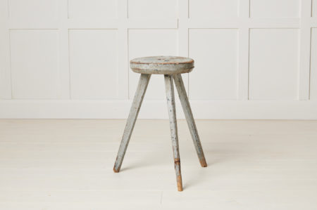 Antique Swedish rustic stool in folk art made with three legs. The stool has a round seat and is in its untouched original condition.