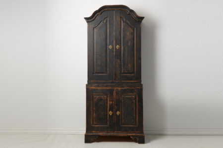 Tall Swedish rococo cabinet made by hand in northern Sweden. The cabinet is a genuine country house furniture from the late 18th century. The cabinet is made from solid pine into two parts.