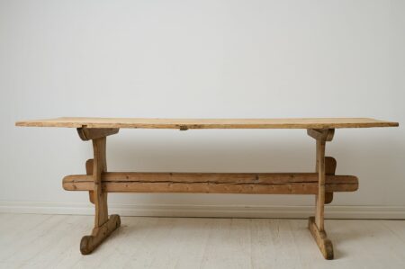 Antique Swedish dining table from the mid 1800s. This antique trestle table has a robust table top in solid pine resting on a leg frame also in solid pine.
