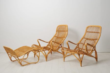 Lounge chairs by Bruno Mathsson in rattan. Indulge in luxury with this pair of iconic lounge chairs by Bruno Mathsson, a rare pair in rattan accompanied by footstools for DUX